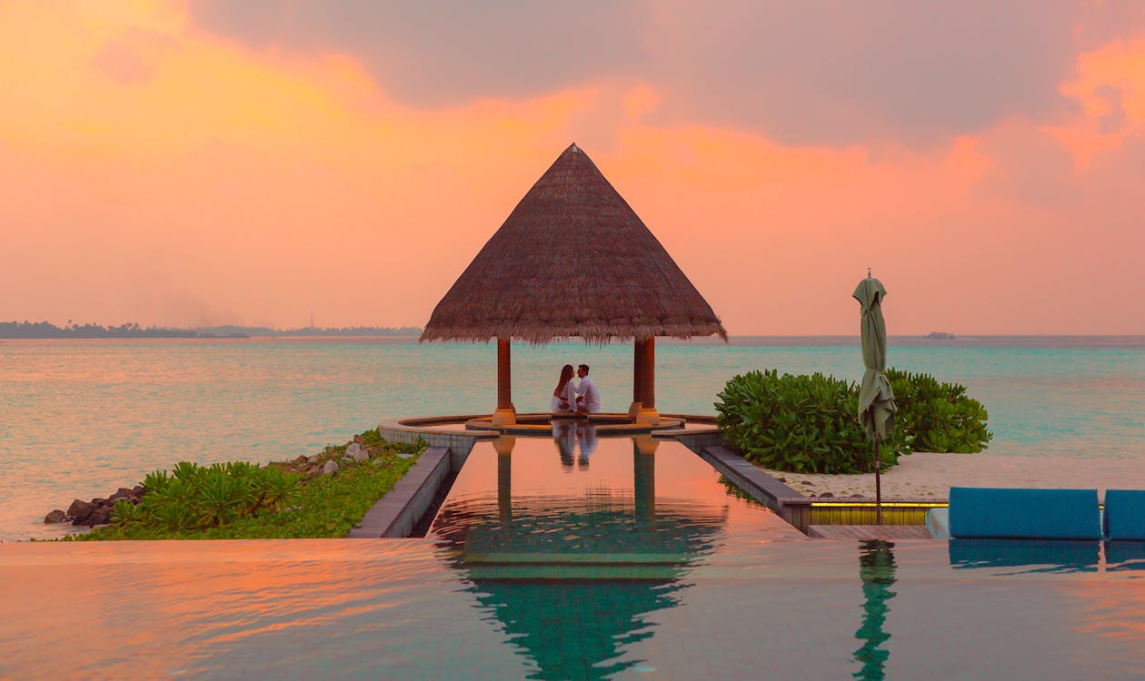 Couple relaxing by infinity pool at sunset – romantic things to do in Bali for couples