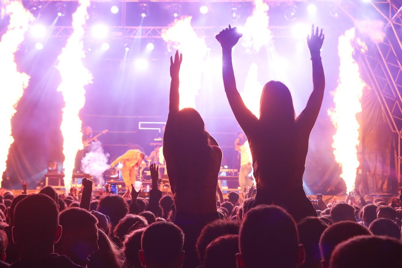 Vibrant concert crowd with fire and pyrotechnic effects on stage – European festival hopping summer 2026
