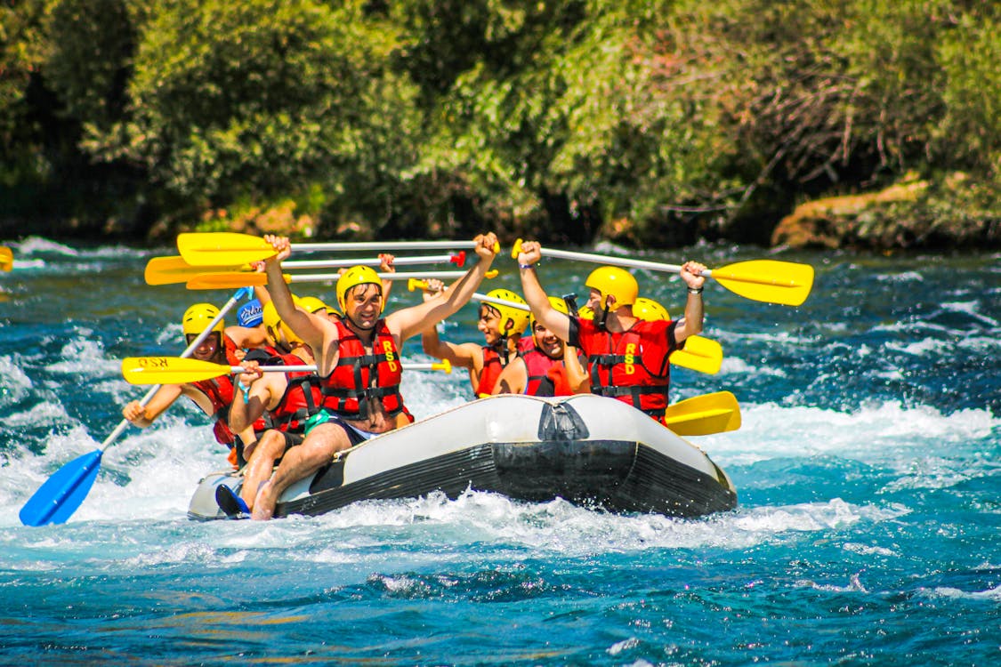 Rafting team paddling inflatable boat through rapids – Telaga Waja Bali whitewater adventure