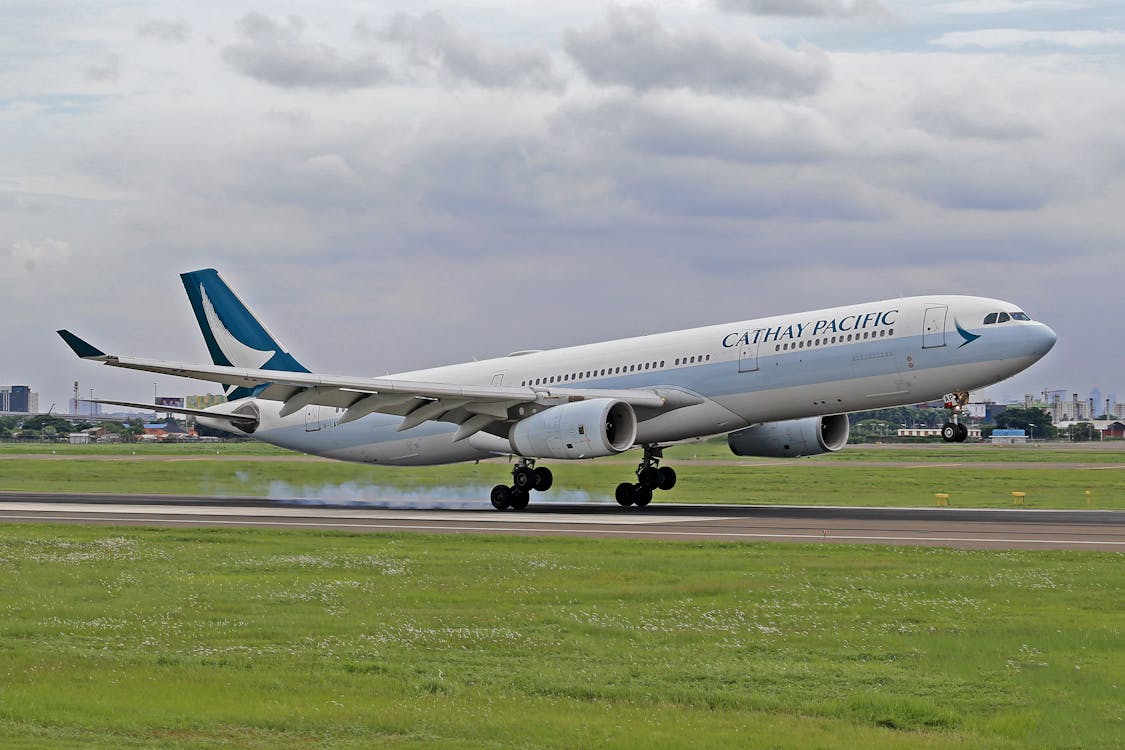 Cathay Pacific airplane landing at airport – multi-city flight hack route planning