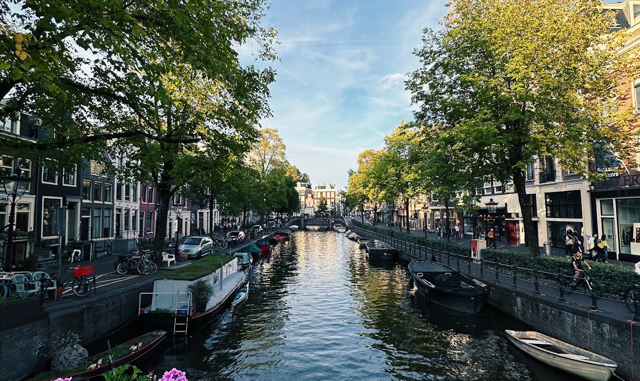 Amsterdam canal with bicycles and boats – moody autumn mystery of Amsterdam canals in shoulder season