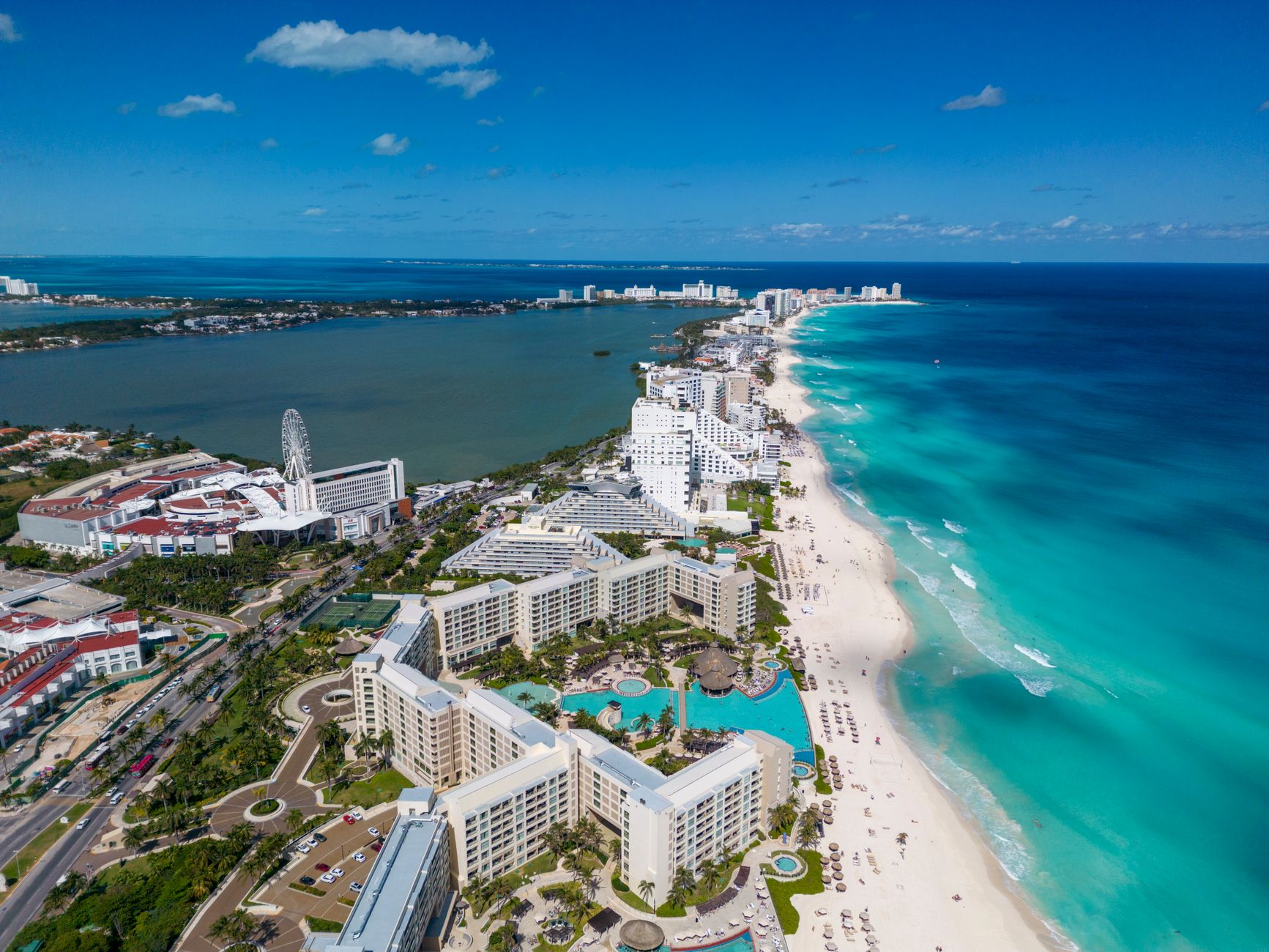 Temptation Cancun in the Cancún hotel zone: a high-energy beachfront party resort — busy pool, modern towers, turquoise