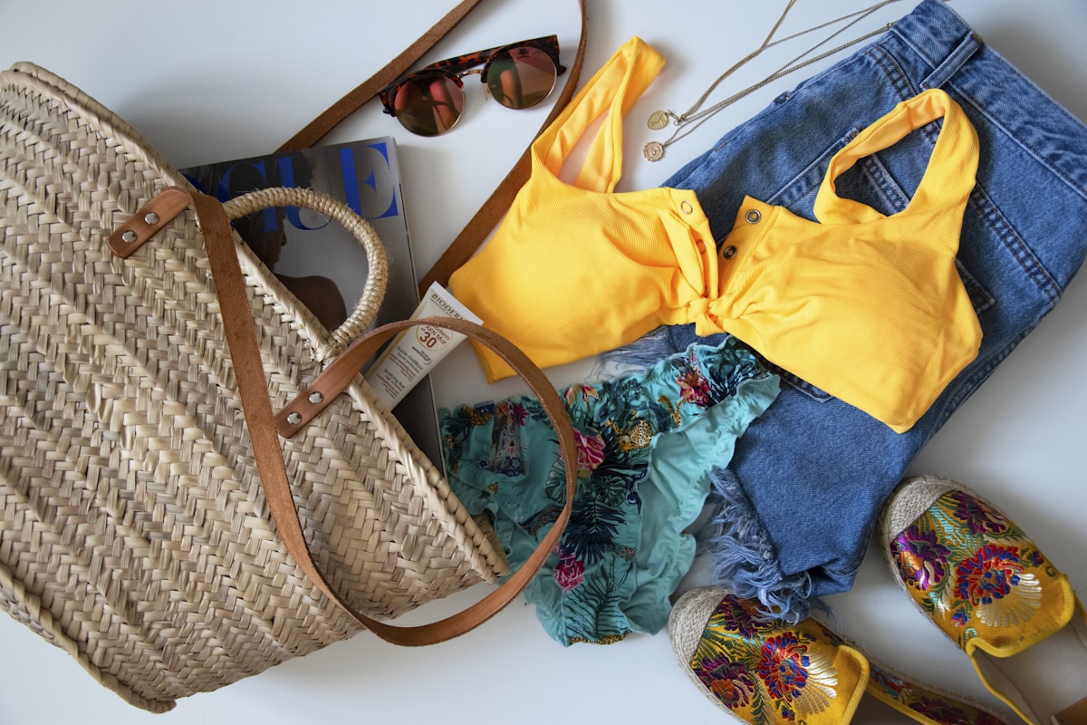Beach packing essentials laid out on sand β what to pack for a nude beach day sunscreen towel sunglasses