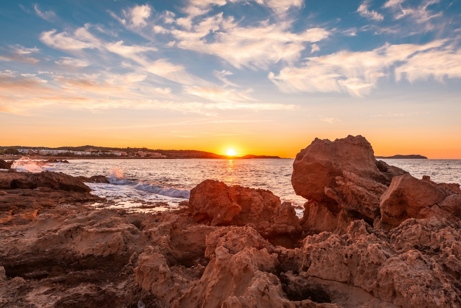 Ibiza Mediterranean rocky coast at sunset with people – your Ibiza adventure starts now