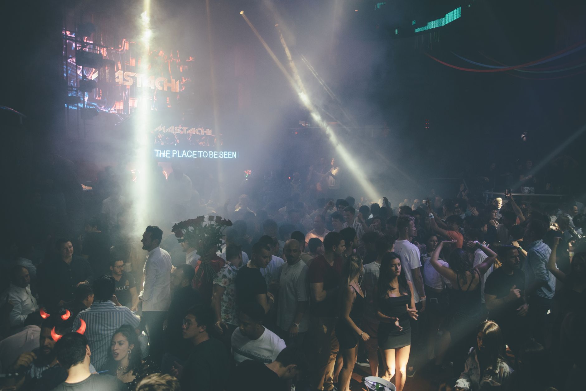 Exciting nightclub scene with a dancing crowd, vibrant lights, and music atmosphere – Which island has the better nightlife overall?
