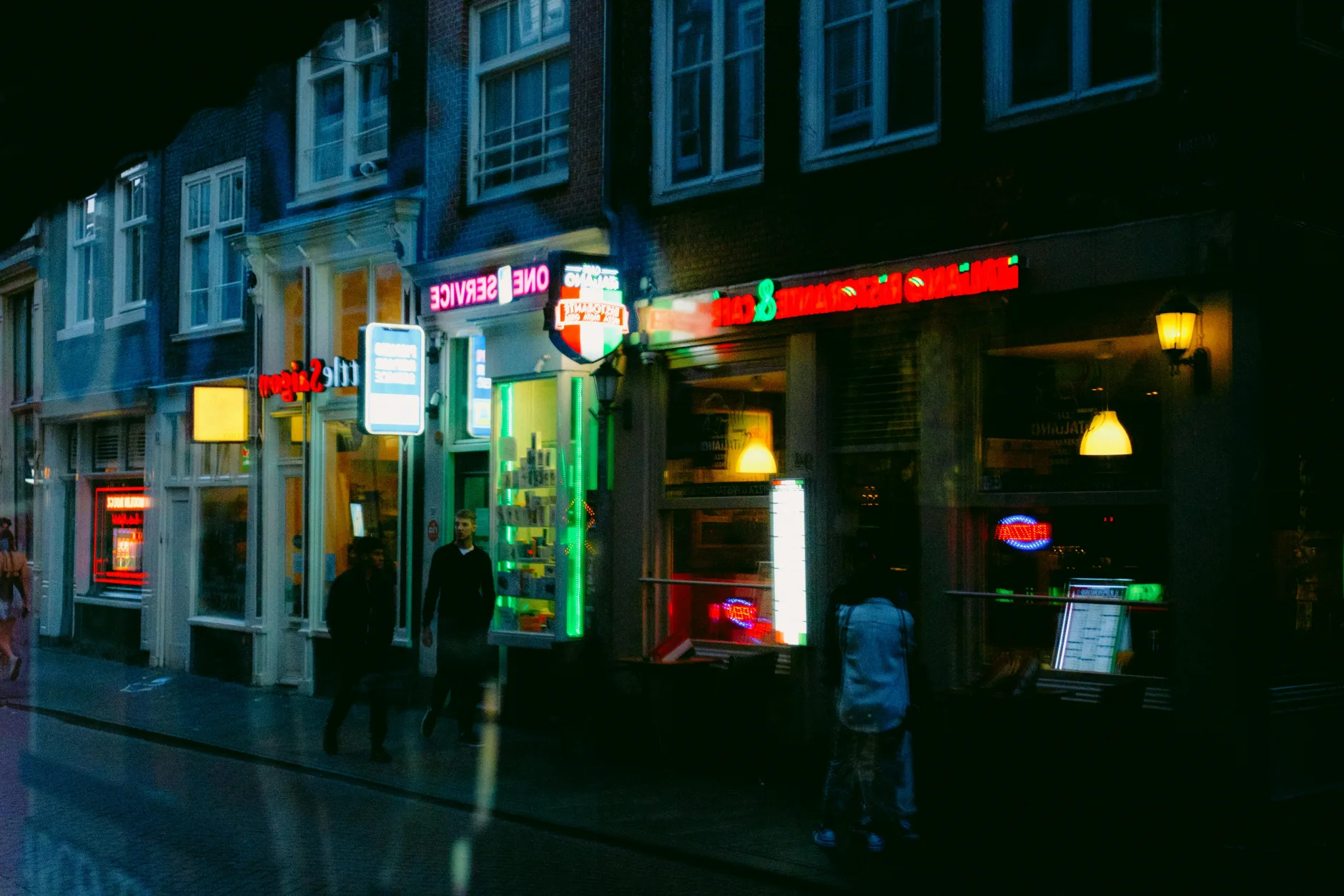 Neon-lit Amsterdam nightlife street with bars and cafes at night - the Netherlands' open lifestyle scene