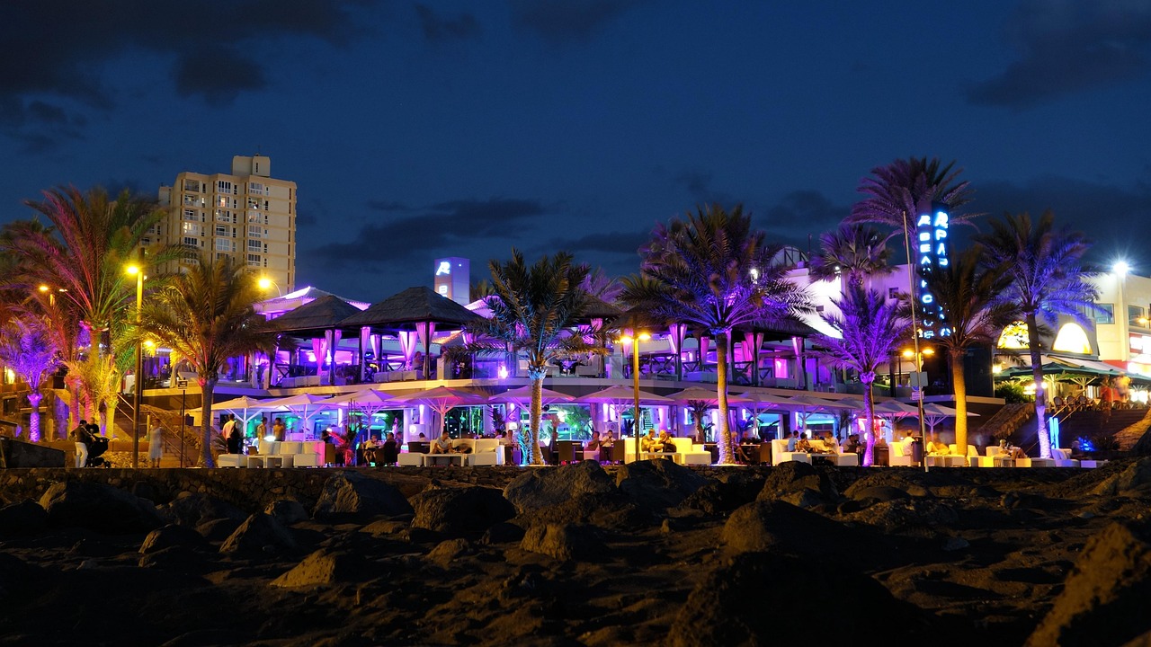 Beachfront nightlife terrace lit up at night β first night out in Playa de las Americas Tenerife