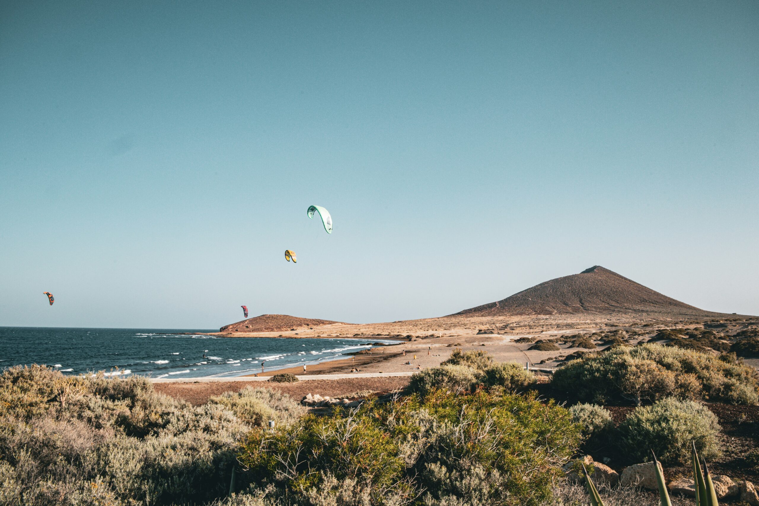 Kite surfers on a sunny day at the beach.