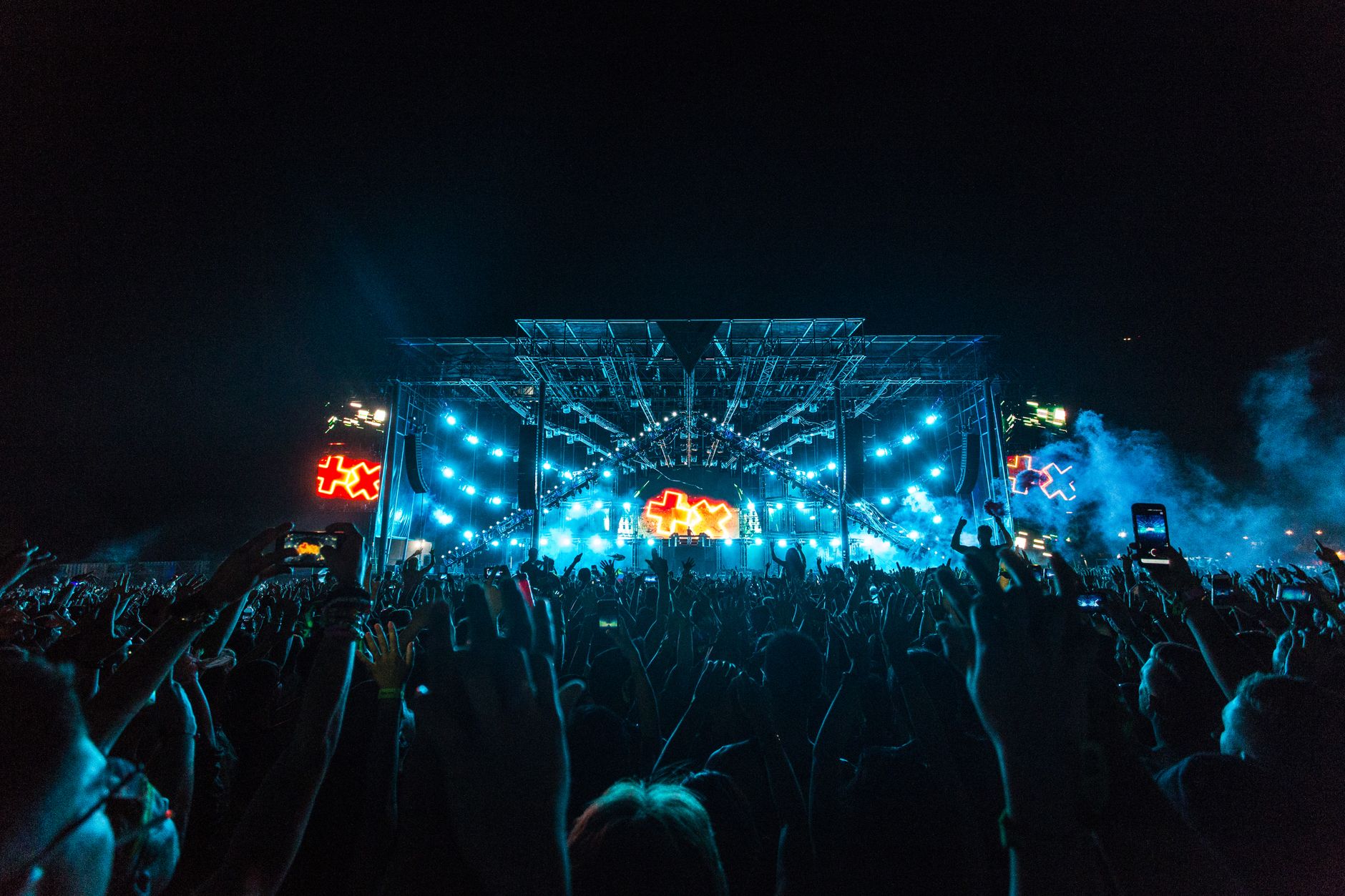 Inside the festival at night: the main stage, crowd, DJ, lights and lasers as the night peaks