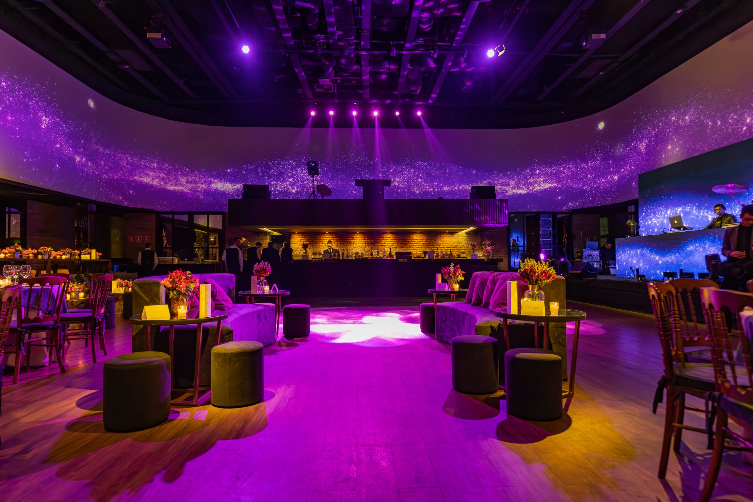Glamorous purple-lit lifestyle club lounge with sofas and dance floor β Barcelona's upscale couples-club scene