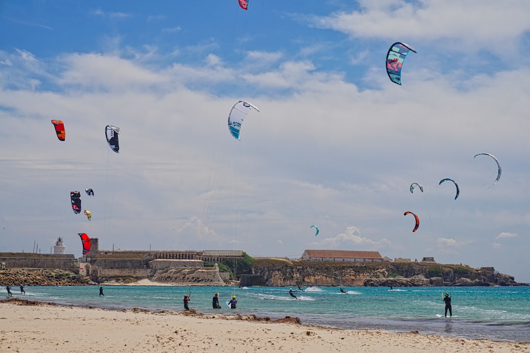 A group of people flying kites on top of a sandy beach – When Is the Best Time to Kitesurf in Tarifa?