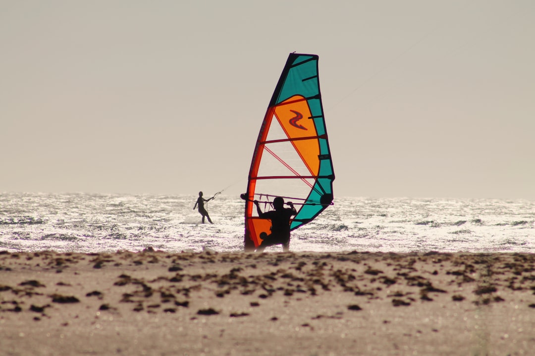 a man riding a wind sail on top of a sandy beach – How Much Does a Kitesurfing Course Cost in Tarifa?