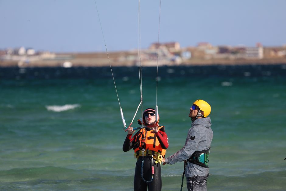 Instructor guiding kitesurfing lesson on a sunny day at the seaside. Safety gear emphasized. – Best Kitesurf Schools in Tarifa for Beginners