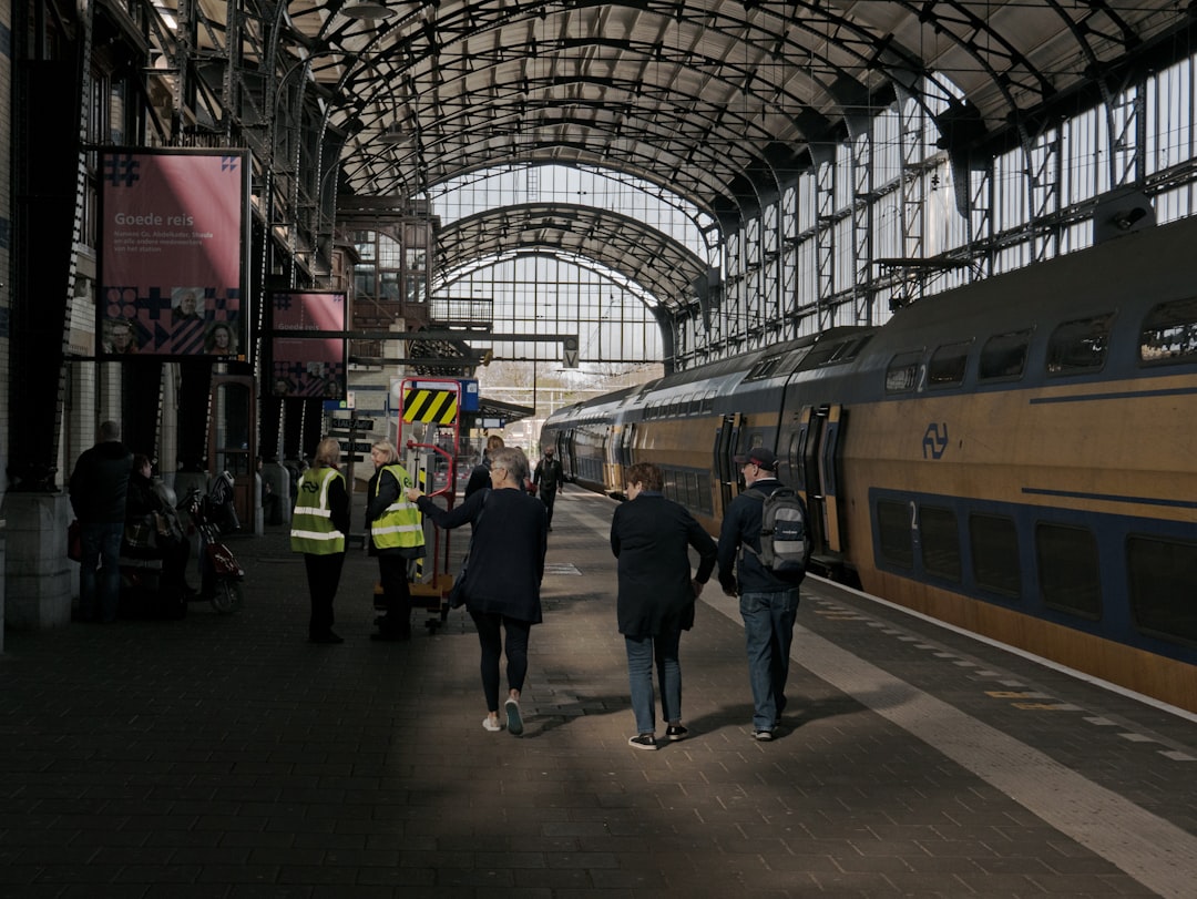 people walking on a platform next to a train – Getting There: Flights, Trains, and the Beekse Bergen Shuttle