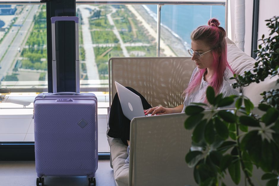 Woman with pink hair working on laptop in hotel room overlooking scenic landscape. Travel and freelance concept. β 7. Skip Incognito Mode β Save the Ritual, Not