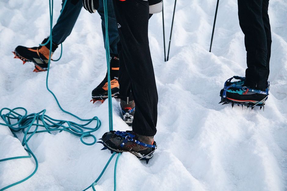 Crampons fitted on hiking boots with climbing rope on glacier ice, Iceland – What to Wear and Pack for the Ice