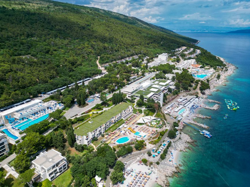 Drone shot of Rabac, Croatia showcasing coastal resorts, forests, and the Adriatic Sea. – Valalta: Croatia's Family-Friendly Naturist Resort
