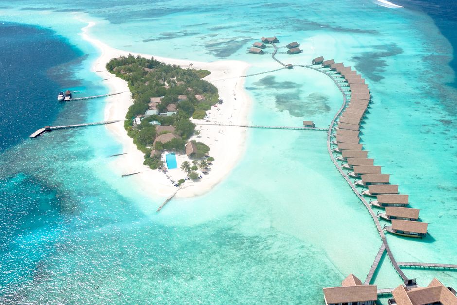 Stunning aerial view of a Maldives resort featuring overwater villas on turquoise waters. – 4. Komandoo Island Resort & Spa — The Adults-Only Pick That Won't Wr