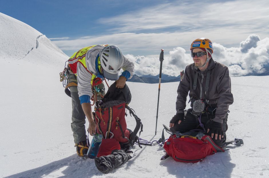 Two climbers equip themselves with gear on a snowy mountain peak in La Paz, Bolivia. – Training, Gear, and Beating Altitude Sickness