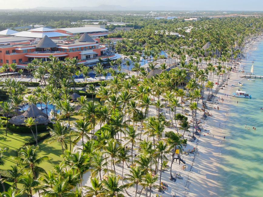 Aerial view of a tropical beach resort lined with palm trees and sandy beaches. – 6. Secrets Royal Beach Punta Cana — Best Value Oceanfront