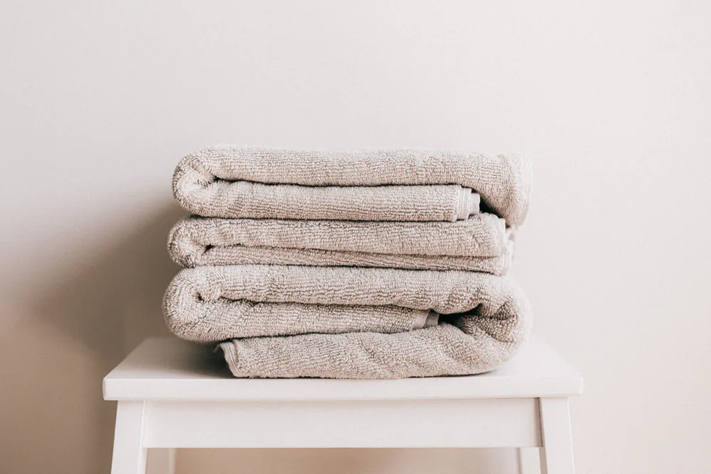 Stack of neatly folded spa towels – always sit on your towel, FKK club etiquette Germany