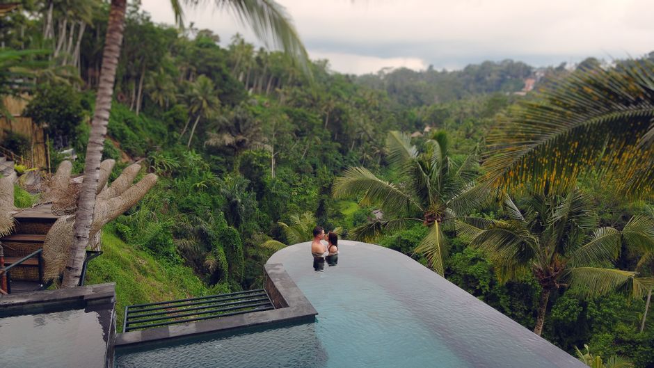 From above side view unrecognizable couple resting and hugging in swimming pool with epic view of tropical jungle in daytime – What "Adults-Only" Really Means i