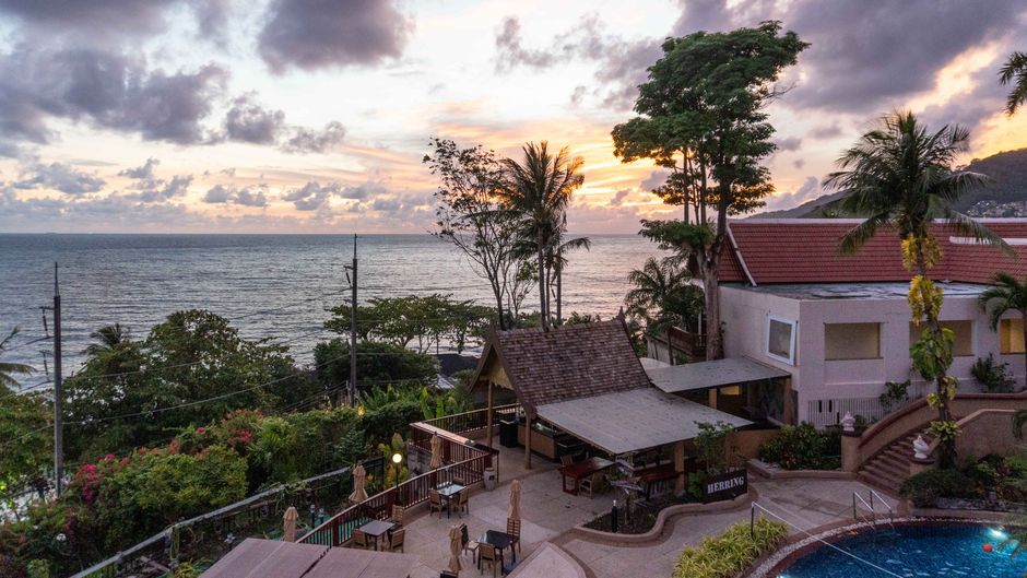 A breathtaking view of a coastal resort with lush greenery and ocean at sunset. – 2. Kalima Resort & Spa — Best for a Real Age Policy
