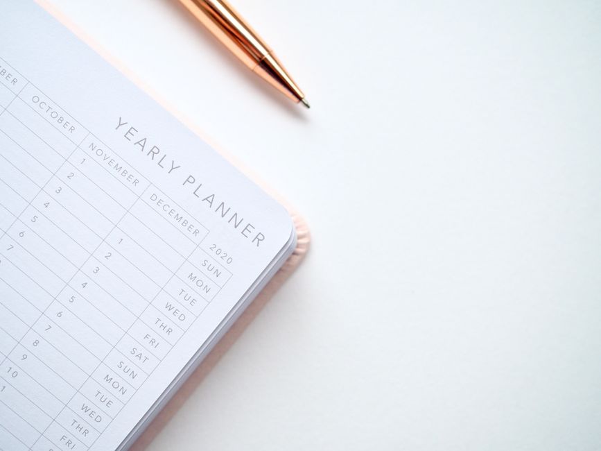 A stylish yearly planner open to a 2020 calendar page, accompanied by a golden pen on a clean white surface. – How to Pick the Right Annual Plan