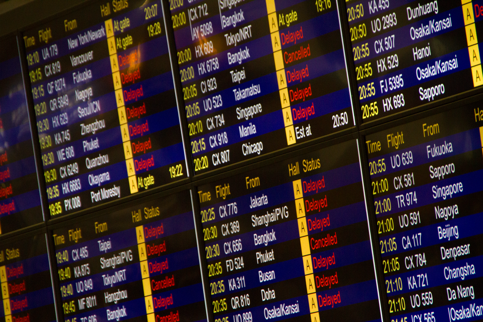 Close-up of digital flight information board showing arrivals and departures at an airport. – What Happens If Your Flight Gets Cancelled Mid-Move?