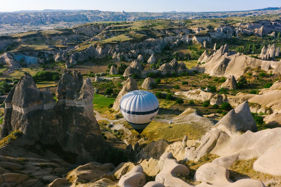 A hot air balloon soaring over the distinctive rock formations of Cappadocia, Turkey. – What Is a Cappadocia Hot Air Balloon Flight Actually Like?