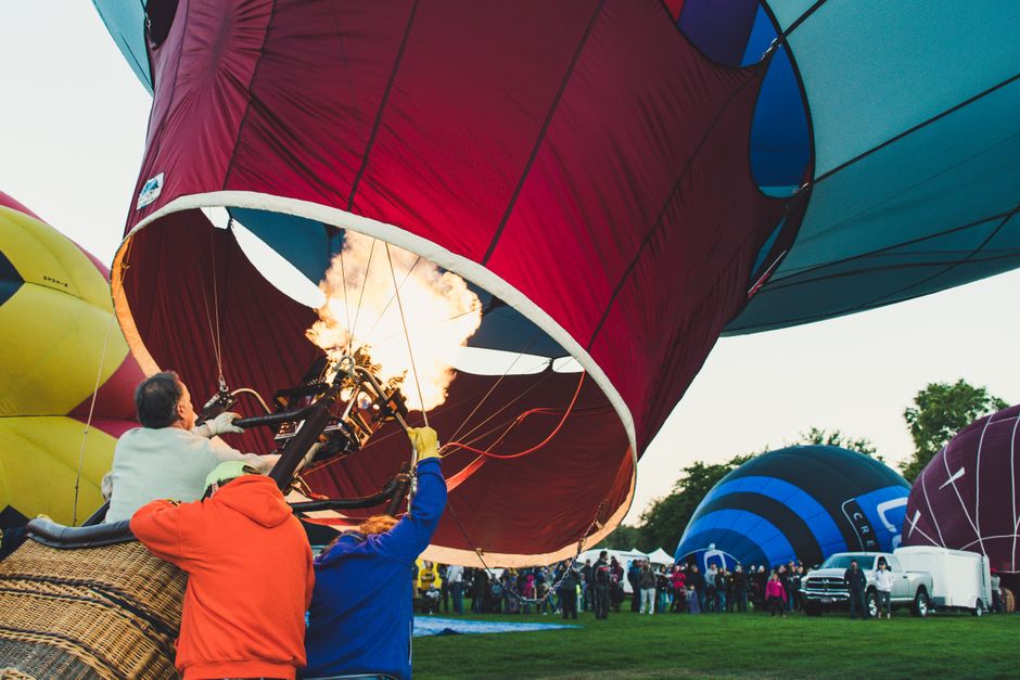 Dynamic scene of adults managing a hot air balloon at an outdoor festival. – How to Choose a Licensed, Safe Balloon Operator