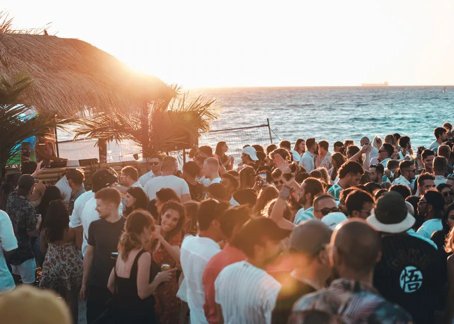 Crowd enjoying a vibrant beach party with stunning sunset views in Australia. – Ready for Beach, Please! 2027?