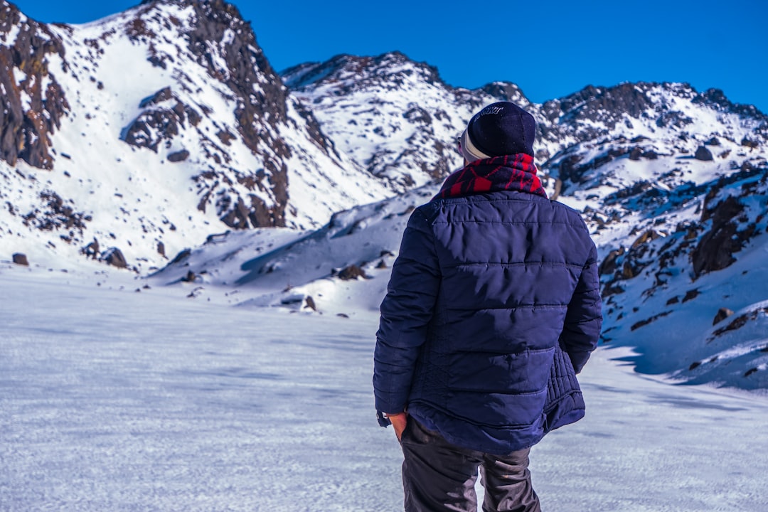man in black jacket and black pants standing on snow covered ground during daytime – What to Wear and Bring