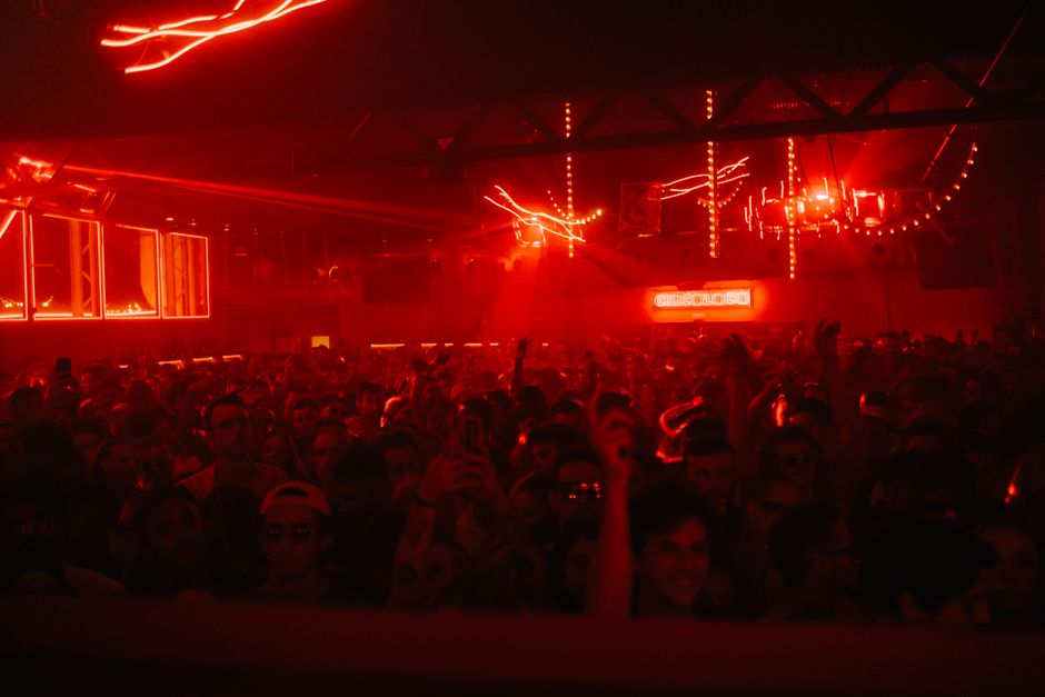 A packed nightclub with a vibrant atmosphere, red lights, and dancing crowd. – DC10 Ibiza: The Underground King