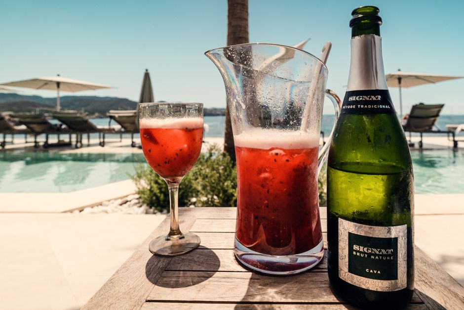 Relax by the pool in Ibiza with a refreshing red cocktail and bubbly cava. – The Real Cost of Ibiza Nightlife in 2026