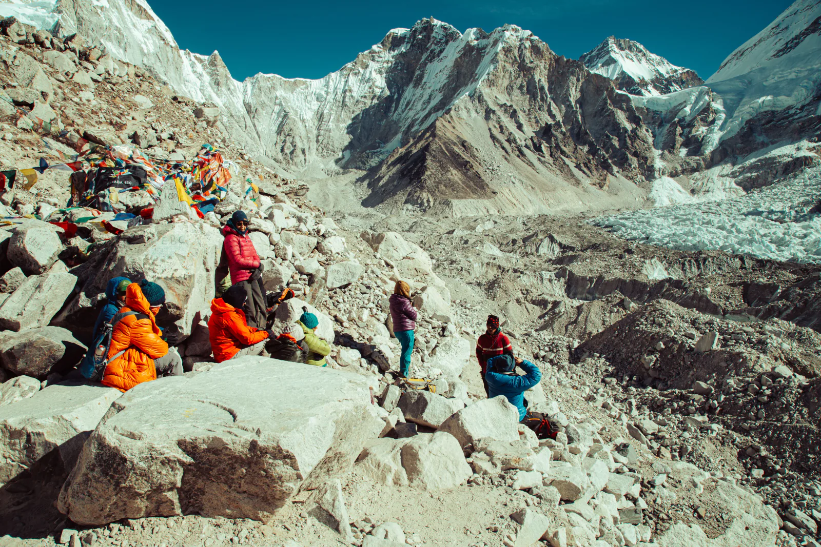 Group of trekkers resting at Everest Base Camp surrounded by prayer flags and snowy peaks in the Himalayas. – How Much Does the Everest Base Camp Trek Cost in 2026?