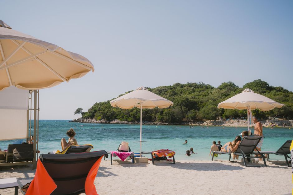 Idyllic beach scene at Ksamil, Albania with umbrellas and sunbathers enjoying the clear sea. – How Much a Day at a Ksamil Beach Club Really Costs