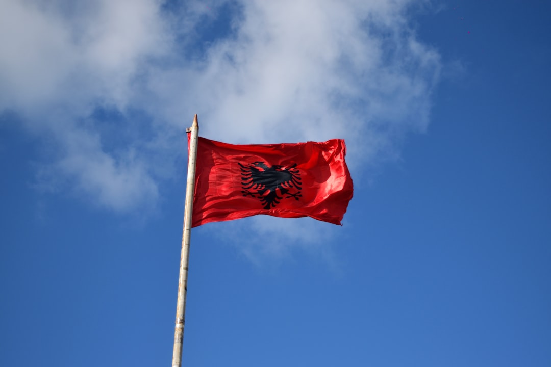 Albanian flag waving against a blue sky – 1. Albania: Europe's Best Value for Money