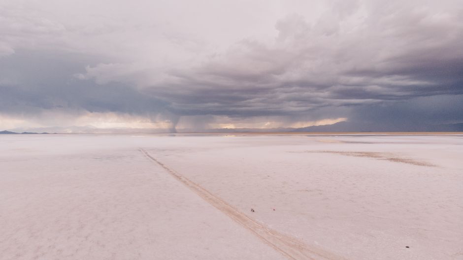 A stunning aerial shot of a desert landscape with a visible whirlwind against stormy clouds. – Know Before You Go: What Recent Years Actually Looked Like