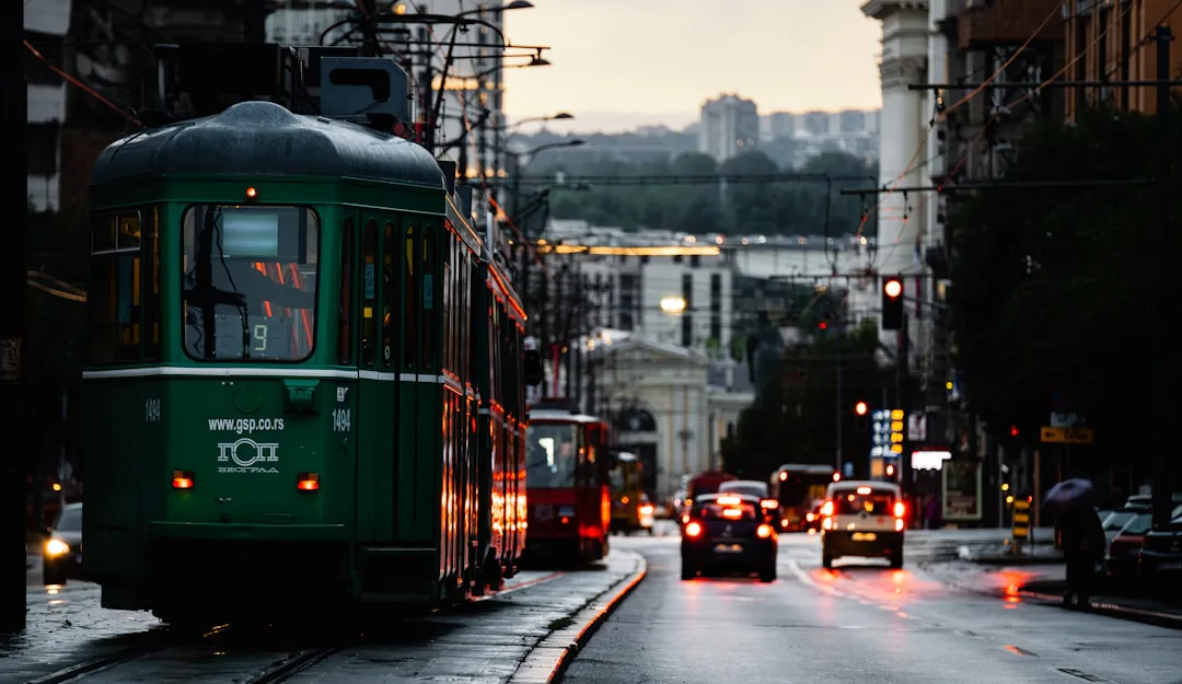 Green GSP tram on a wet Belgrade street at dusk – getting around Belgrade on New Year's Eve