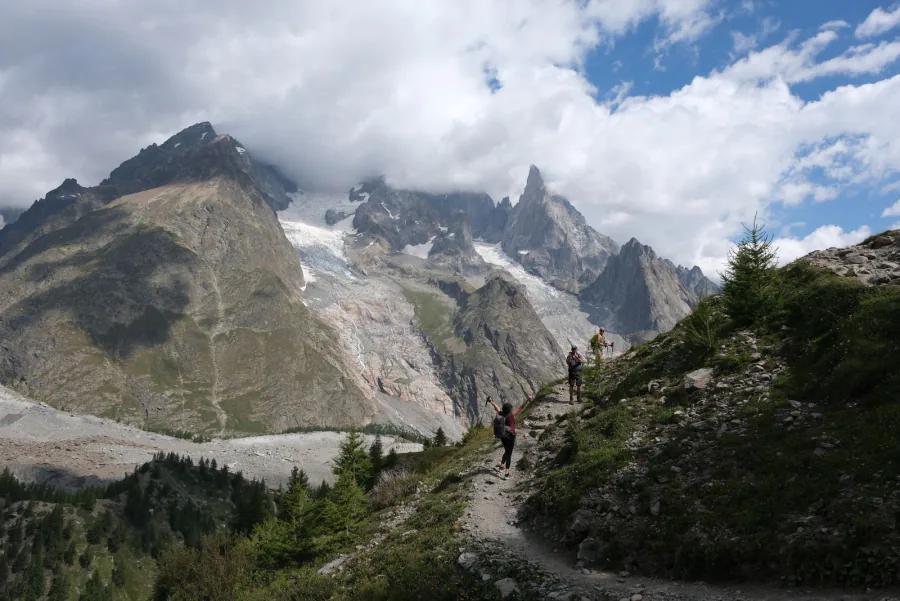 Hikers on a rocky trail below the Mont Blanc glaciers – what the TMB is and how long it takes, Mont Blanc massif