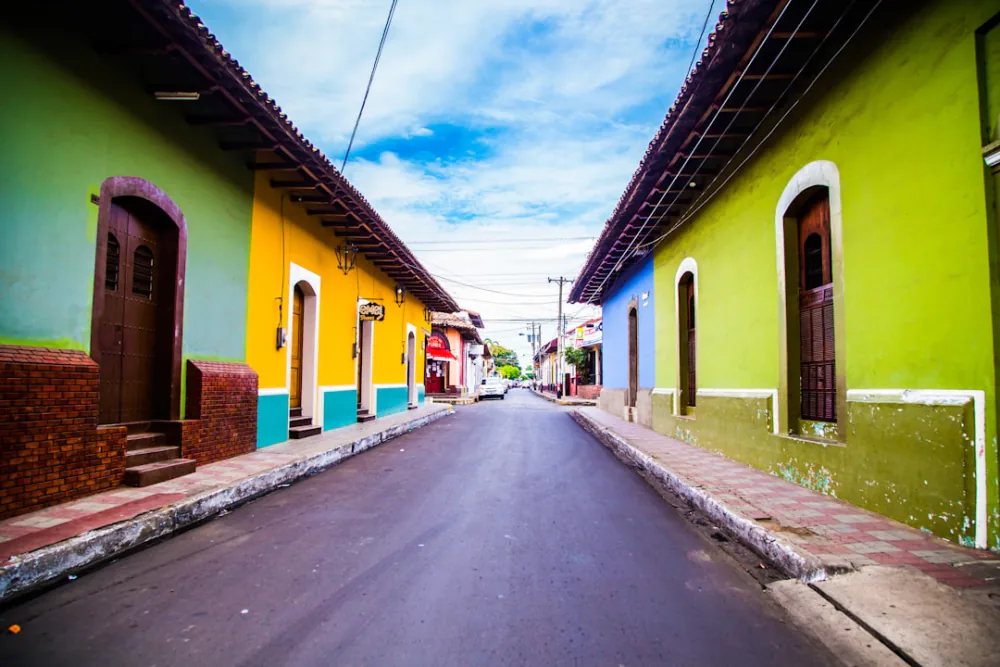 Pastel colonial street in central Leon where tour shuttles depart – getting to Cerro Negro, Nicaragua