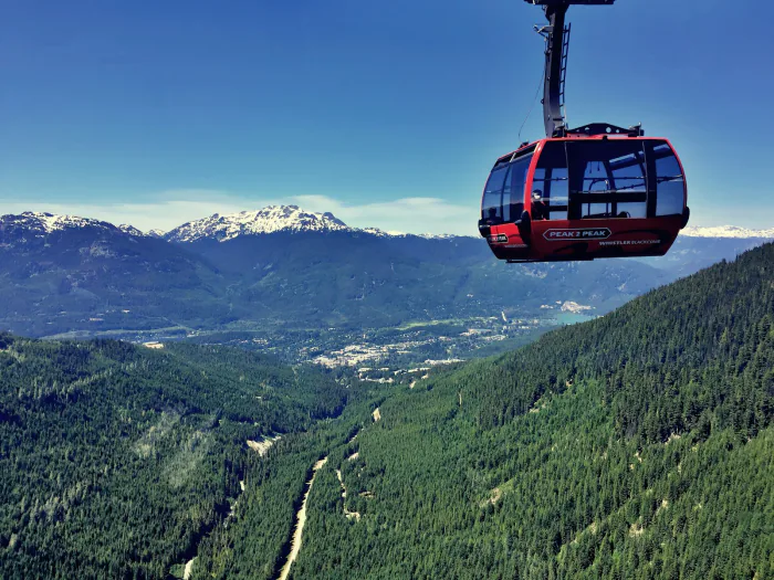 PEAK 2 PEAK gondola cabin above green summer slopes – Whistler Bike Park 2026 season timing, Whistler BC