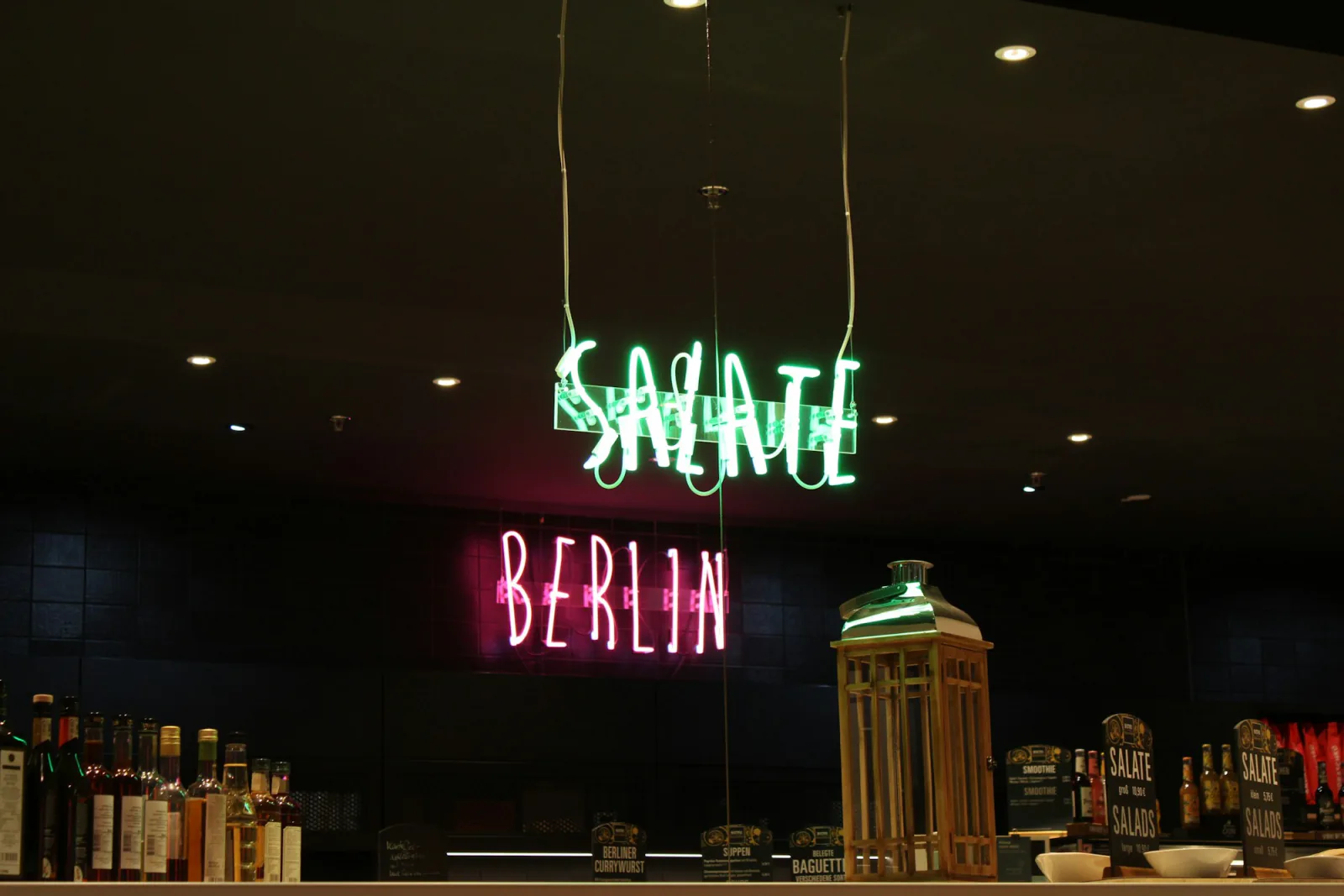 Neon signs for "salate" and "berlin" above bar – What do you drink at a Berlin club when you're not drinking?