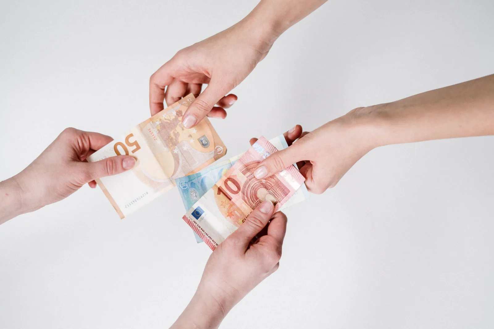 Two pairs of hands exchanging Euro banknotes, symbolizing finance and transaction. – What does a sober Berlin night actually cost?