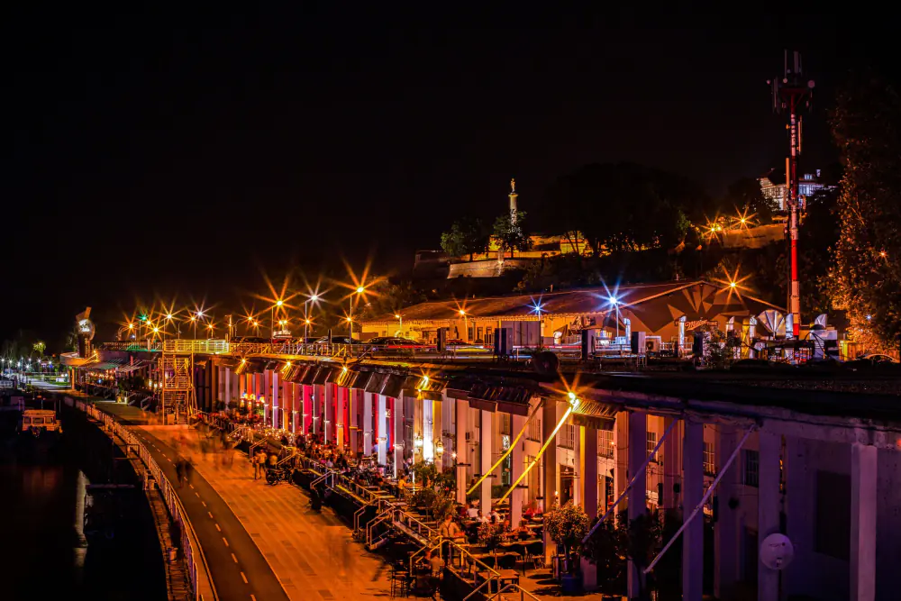 Illuminated riverbank bars and terrace seating on a warm night out – Which city is cheaper for a full night out?