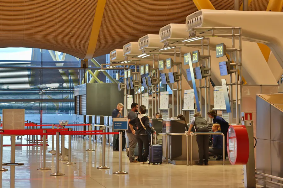 Traveller sorting out a booking issue at an airport service counter - hidden fees that catch flyers out