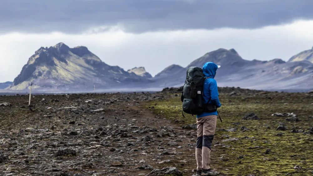 Lone backpacker crossing volcanic highland terrain – Laugavegur trail difficulty, Iceland
