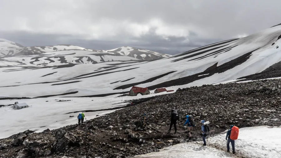 Hikers on a snow-streaked mountain pass near Landmannalaugar – Laugavegur trail costs, Iceland
