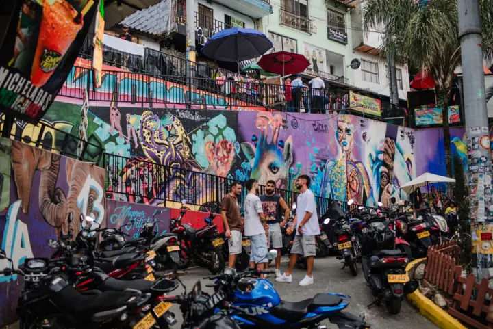 Dynamic street scene featuring colorful graffiti and local culture in Medellín, Colombia. – Where Should You Go Out in Medellín: Poblado, Provenza or Laureles?